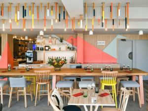 une cuisine avec une grande table et des chaises en bois dans l'établissement Mercure Annemasse Porte De Genève, à Gaillard