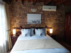 Un dormitorio con una cama y una pared de ladrillo. en Khumbula iAfrica 1, en Marloth Park 28 fotos más