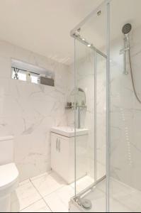 a white bathroom with a shower and a toilet at SLS VACATION STAY in Kent