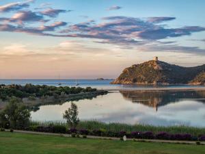 a view of a small island in the water with a lighthouse at Almar Timi Ama Resort & Spa in Villasimius