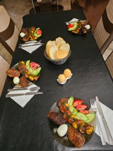 a black table with plates of food on it at Guesthouse different in Tbilisi City
