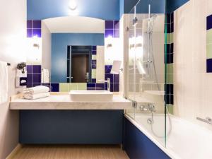 La salle de bains est pourvue d'un lavabo et d'une douche. dans l'établissement Mercure Bordeaux Centre Ville, à Bordeaux