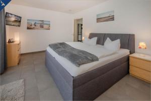 a bedroom with a large bed in a room at Villen am See - Villa Petra Whg Ahlbeck in Korswandt