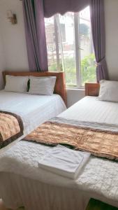 2 camas individuales en una habitación con ventana en Ks Huy Hoang Airport en Hanói