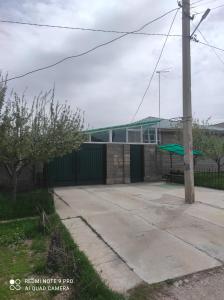 ein Gebäude mit einem grünen Dach neben einem Bürgersteig in der Unterkunft Your House in Karakol
