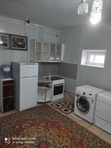 a kitchen with a washing machine and a washer at Your House in Karakol