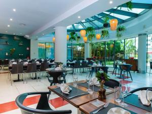 a restaurant with tables and chairs and glass ceilings at Ibis Antananarivo Ankorondrano in Antananarivo