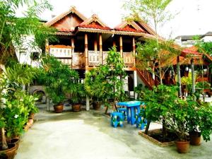 una casa con una mesa azul delante de ella en Suksomjai Hotel, en Rayong