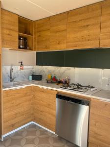 La cuisine est équipée de placards en bois et d'un four avec plaques de cuisson. dans l'établissement Mobile-home tout équipé avec Jacuzzi, à Porto-Vecchio