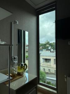 a kitchen with a window with a view of a building at Aisi kutaisi in Kutaisi