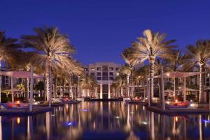 un complexe avec des palmiers en face d'un bâtiment dans l'établissement Park Hyatt Abu Dhabi Hotel and Villas, à Abu Dhabi