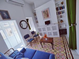 a living room with a blue couch and a table at Traditional Maltese townhouse in Rabat in Rabat