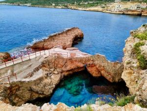 a cave in the rocks next to a body of water at Mezapos Villa Katerina in Mézapos