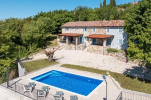 an external view of a house with a swimming pool at Madonna delle Nevi in Oprtalj