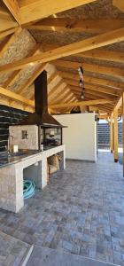 uma cozinha exterior com um fogão num tecto de madeira em Relax Vučković em Ivanjica