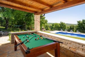 a pool table on a patio with a swimming pool at Madonna delle Nevi in Oprtalj