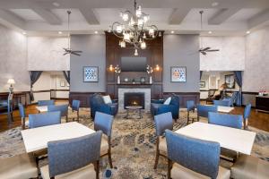 a lobby with tables and chairs and a fireplace at Homewood Suites by Hilton Davidson in Davidson