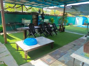a patio with a table and chairs and a blue frisbee at Homestay Megat & Puteri in Kampong Tanjong Putus