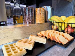 a table with waffles and bread and waffles and fruit at ibis budget Coutances in Coutances