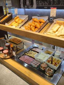 une caisse d'exposition dans une boulangerie avec des pâtisseries et du pain dans l'établissement ibis budget Coutances, à Coutances