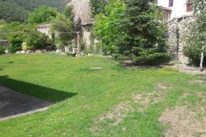 una antigua casa de piedra con un patio de césped en El Refugio de Santi, en Butrera