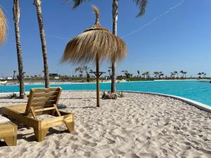 - une plage avec une chaise, un parasol et l'eau dans l'établissement MADRESELVA 62.29, à Torre-Pacheco