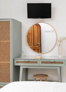 a dressing table with a mirror and a tv on a wall at Hotel Il Girasole in Anacapri