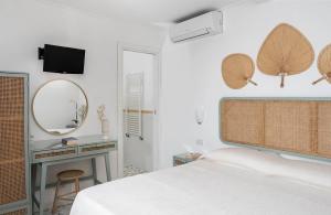a bedroom with a bed and a desk and a mirror at Hotel Il Girasole in Anacapri