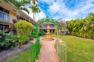 a green gate leading to a garden with a fountain at Quality Inn & Suites Airport-Cruise Port Hollywood in Hollywood