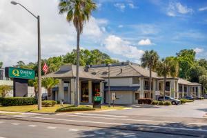 a street view of a hotel with a palm tree at Quality Inn Gainesville near University in Gainesville