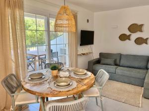 Apartamento Brisa de Menorca في سون بارك: غرفة معيشة مع طاولة مع كراسي وأريكة