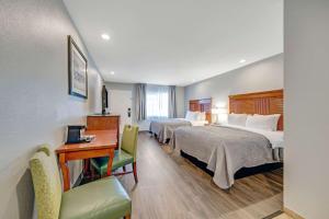 a hotel room with two beds and a desk at Quality Inn in Santa Cruz