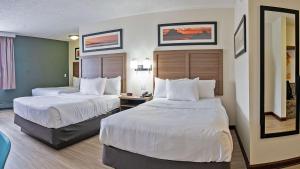 ein Hotelzimmer mit 2 Betten mit weißer Bettwäsche in der Unterkunft Quality Inn Milan-Sandusky in Milan