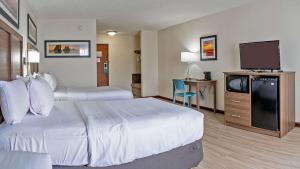 ein Hotelzimmer mit 2 Betten und einem Flachbild-TV in der Unterkunft Quality Inn Milan-Sandusky in Milan