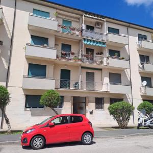 um carro vermelho estacionado em frente a um edifício em Bubi's apartment, intero appartamento di 65mq em Livorno