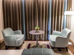 ブエノスアイレスにあるPalladio Hotel Buenos Aires - MGalleryのカーテン付きの部屋(椅子2脚、テーブル1台付)