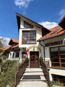 une maison avec un escalier menant à la porte d'entrée. dans l'établissement Hotel Promyk Wellness & Spa, à Karpacz