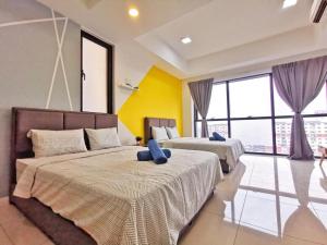 Duas camas num quarto com paredes amarelas e janelas em ICON City, Petaling Jaya em Petaling Jaya