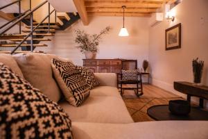a living room with a couch and a staircase at Quinta de São Francisco Houses in Viseu