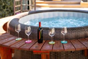 - une bouteille de vin et trois verres à vin sur une table en bois dans l'établissement Palmira Apartments, à Poreč