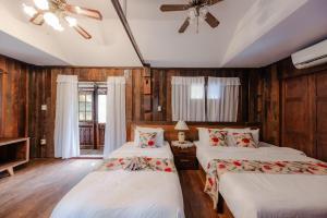 - une chambre avec 2 lits et un ventilateur de plafond dans l'établissement Chiang Mai Las Orquideas Resort, à Chiang Mai