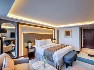pokój hotelowy z łóżkiem i salonem w obiekcie Queen Elizabeth 2 Hotel w Dubaju