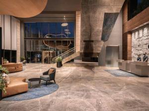 a lobby of a building with a chair and a table at Novotel Chandigarh Tribune Chowk in Chandīgarh