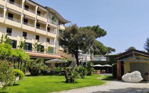 a hotel with a garden and a building at Hotel Acapulco in Forte dei Marmi