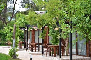 eine Gruppe von Tischen und Stühlen in einem Garten in der Unterkunft Koala Bungalows in Olympos