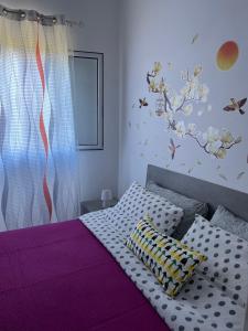 - une chambre dotée d'un lit avec des draps violets et des oiseaux sur le mur dans l'établissement Monolocale Rosy 2, à Porto