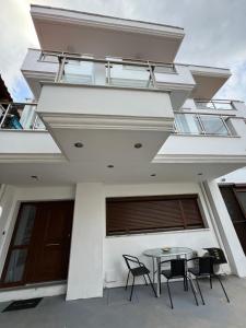 a house with a balcony with a table and chairs at Penelope's apartment Ι in Potamiá