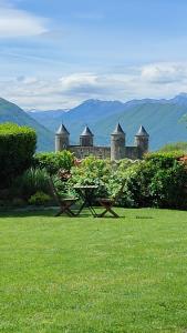 a table and chairs in front of a castle at Un petit coin de paradis à Haute Jarrie in Jarrie