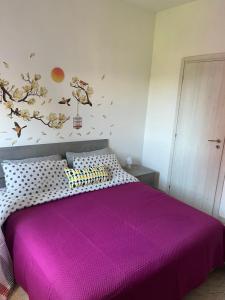 ein Schlafzimmer mit einem Bett mit einer lila Tagesdecke in der Unterkunft Monolocale Rosy 2 in Porto