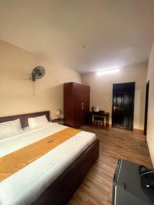 Ðông Hà的住宿－Khách sạn HOÀ BÌNH QUẢNG TRỊ，一间卧室配有一张大床和一张书桌